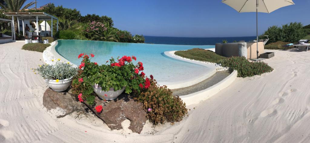 Piscina a sfioro sulla spiaggia bianca.